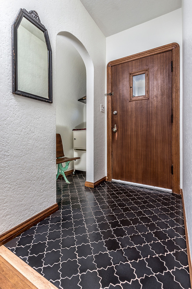 Ispirazione per una piccola porta d'ingresso con pareti bianche, pavimento con piastrelle in ceramica, una porta singola, una porta marrone e pavimento nero
