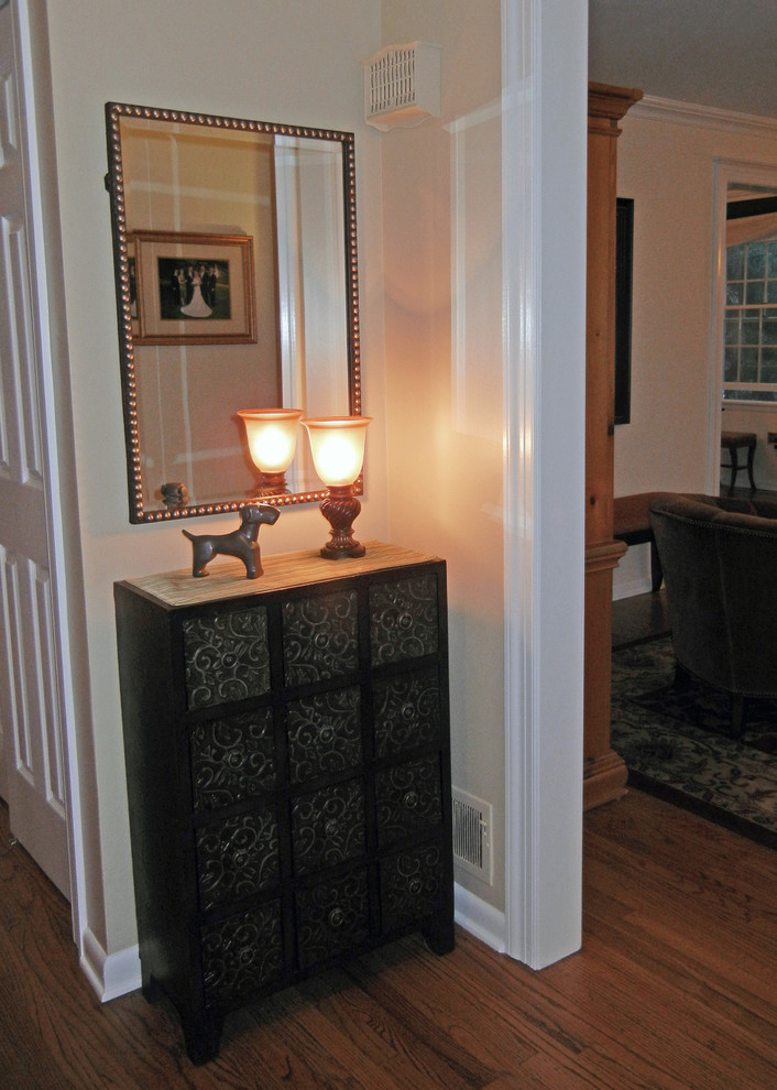Kleines Klassisches Foyer mit beiger Wandfarbe, Einzeltür, braunem Holzboden und schwarzer Haustür in New York