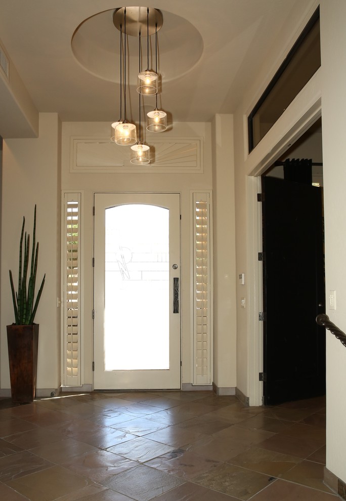 Стильный дизайн: большое фойе в современном стиле с белыми стенами, полом из керамогранита, одностворчатой входной дверью, белой входной дверью и коричневым полом - последний тренд