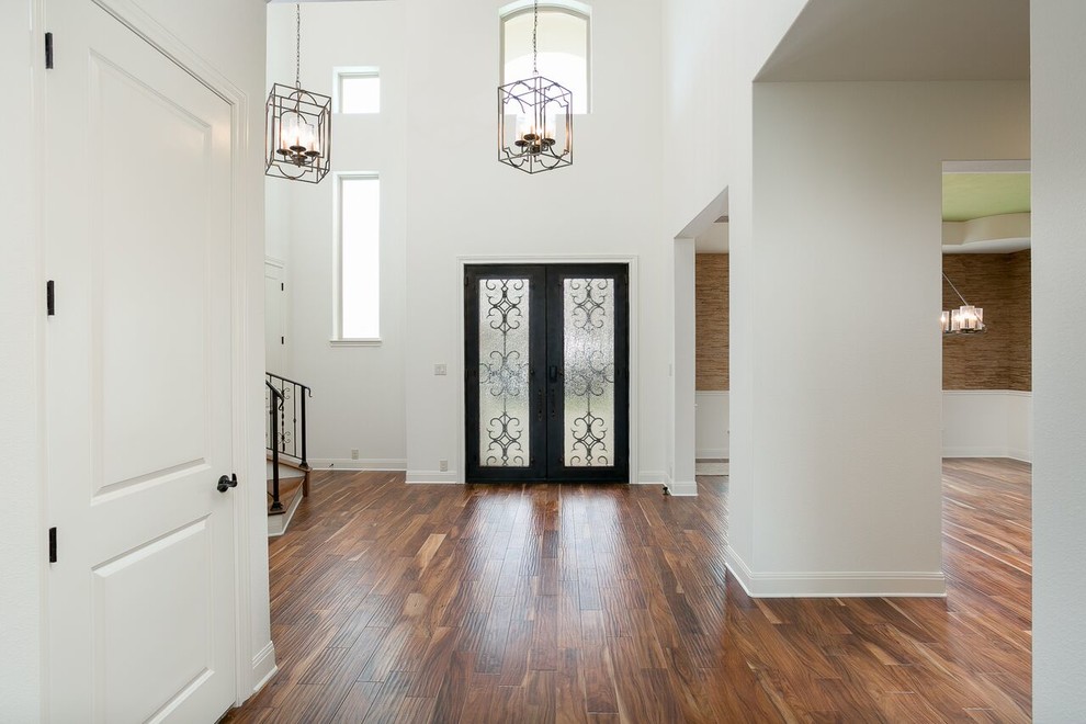 Foto di un grande ingresso classico con pareti bianche, pavimento in bambù, una porta a due ante, una porta in legno scuro e pavimento marrone