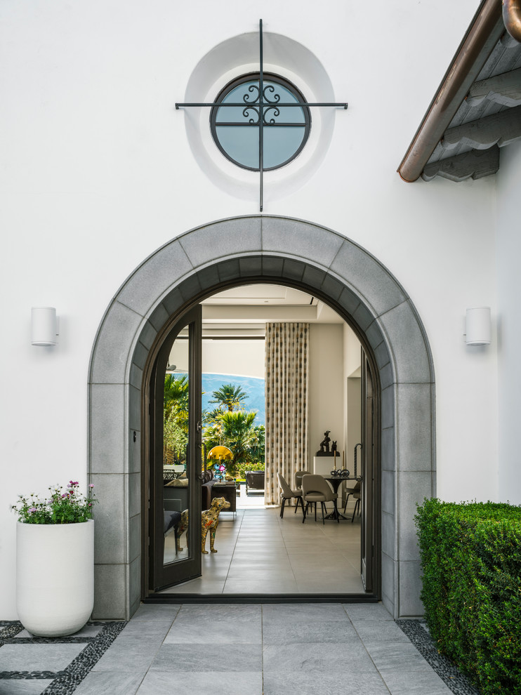 Foto di una piccola porta d'ingresso mediterranea con pareti bianche, pavimento in gres porcellanato, una porta a due ante, pavimento grigio e una porta in vetro