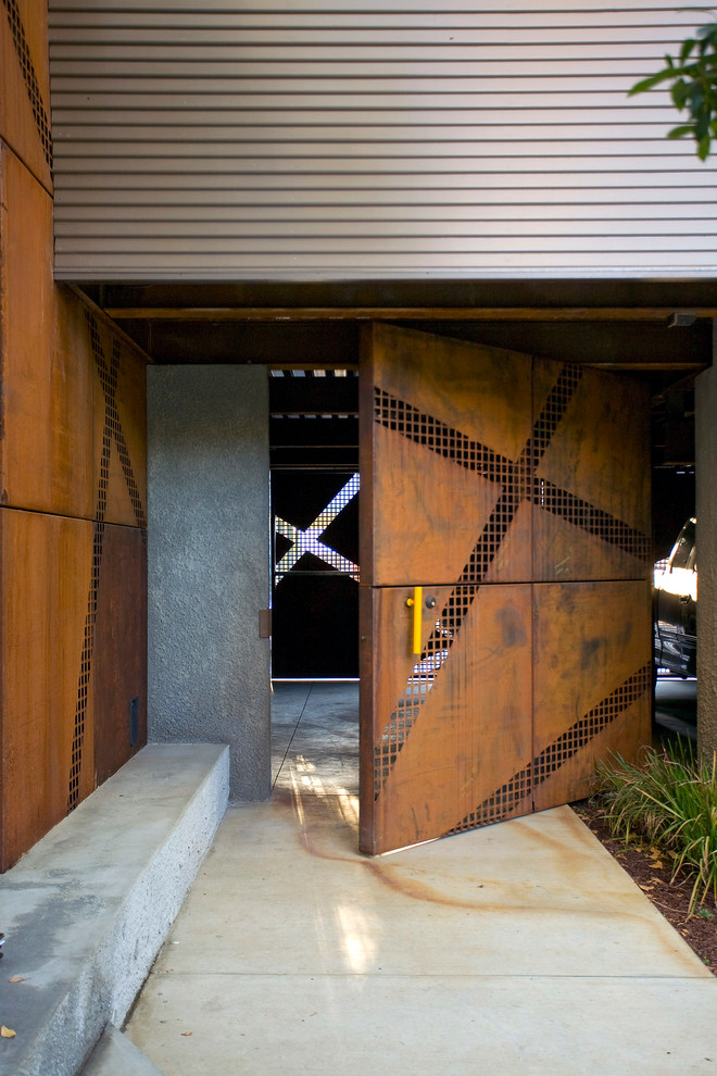 Inspiration pour une porte d'entrée urbaine avec une porte pivot et une porte métallisée.
