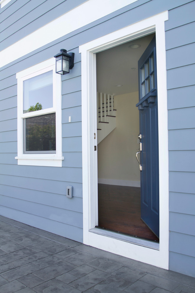 Inspiration pour une porte d'entrée craftsman de taille moyenne avec sol en béton ciré, une porte simple et une porte bleue.