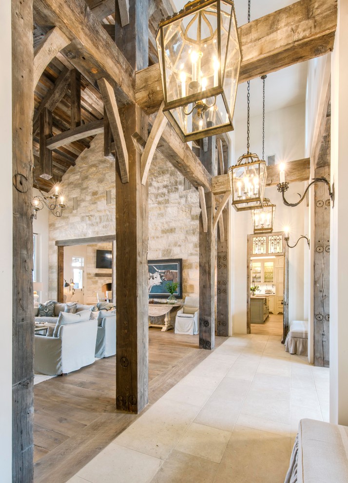 Entryway - huge country limestone floor and beige floor entryway idea in Austin with white walls and a black front door