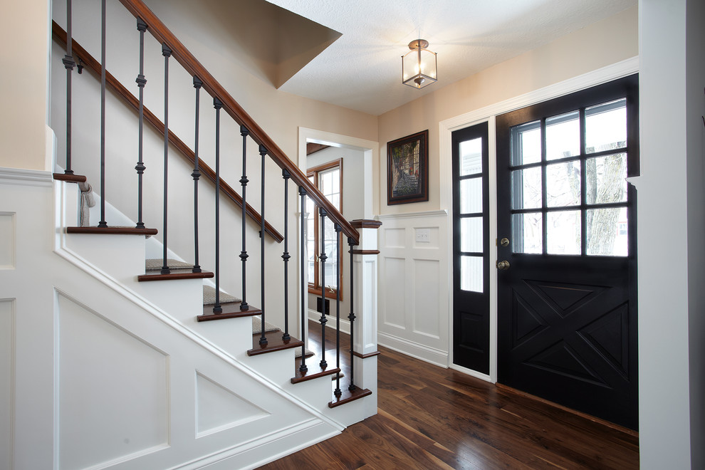 This is an example of a classic foyer in Minneapolis with beige walls, medium hardwood flooring, a single front door and a black front door.