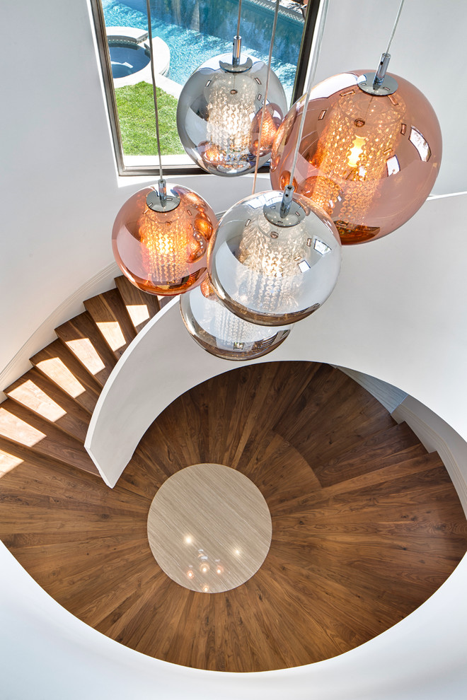 Example of a large trendy medium tone wood floor foyer design in Los Angeles with white walls