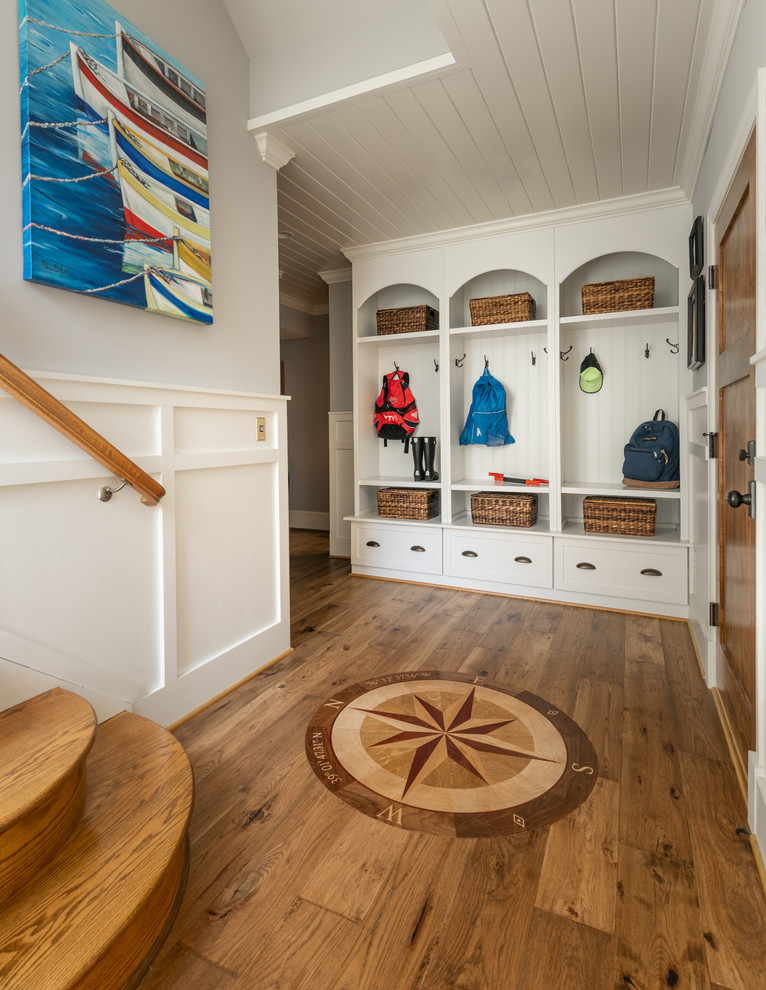 Modelo de vestíbulo posterior marinero de tamaño medio con paredes grises, suelo de madera en tonos medios, puerta simple y puerta de madera en tonos medios