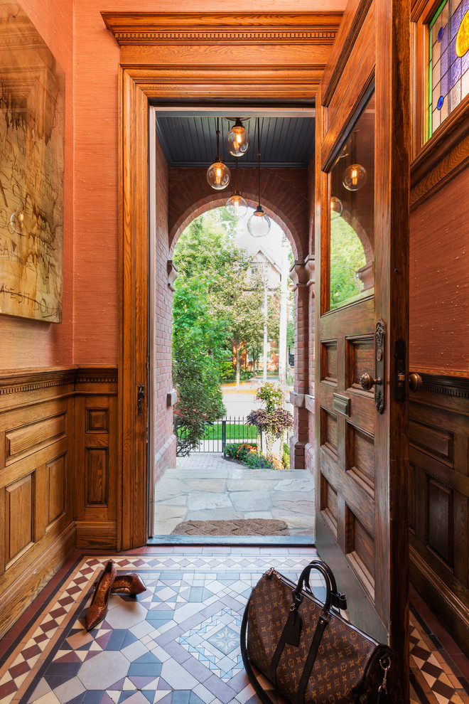 Imagen de puerta principal bohemia pequeña con suelo de madera clara, puerta simple, puerta de madera en tonos medios y paredes rosas
