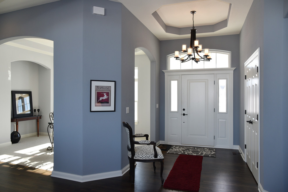 Esempio di un ingresso chic di medie dimensioni con pareti blu, parquet scuro, una porta singola e una porta bianca