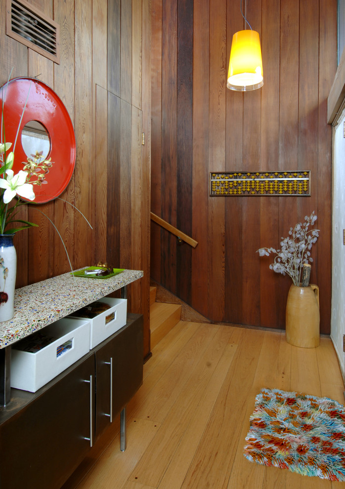 Immagine di un ingresso minimalista di medie dimensioni con pareti marroni e parquet chiaro