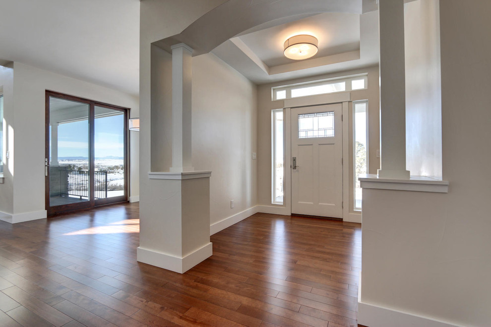 Entryway - mid-sized craftsman medium tone wood floor entryway idea in Denver with white walls and a white front door