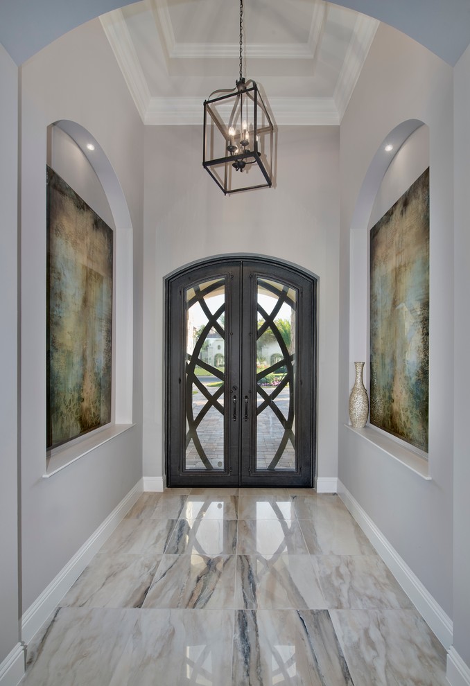 Ejemplo de hall mediterráneo de tamaño medio con paredes beige, puerta doble, puerta de vidrio y suelo multicolor