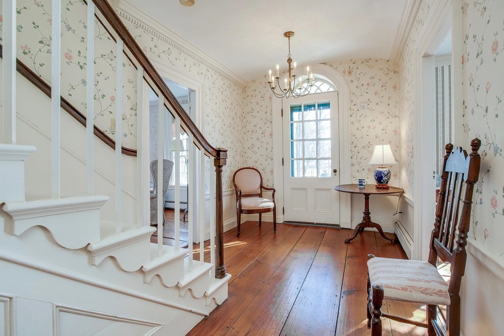 Klassischer Eingang mit bunten Wänden, dunklem Holzboden, Einzeltür, weißer Haustür und braunem Boden in Boston