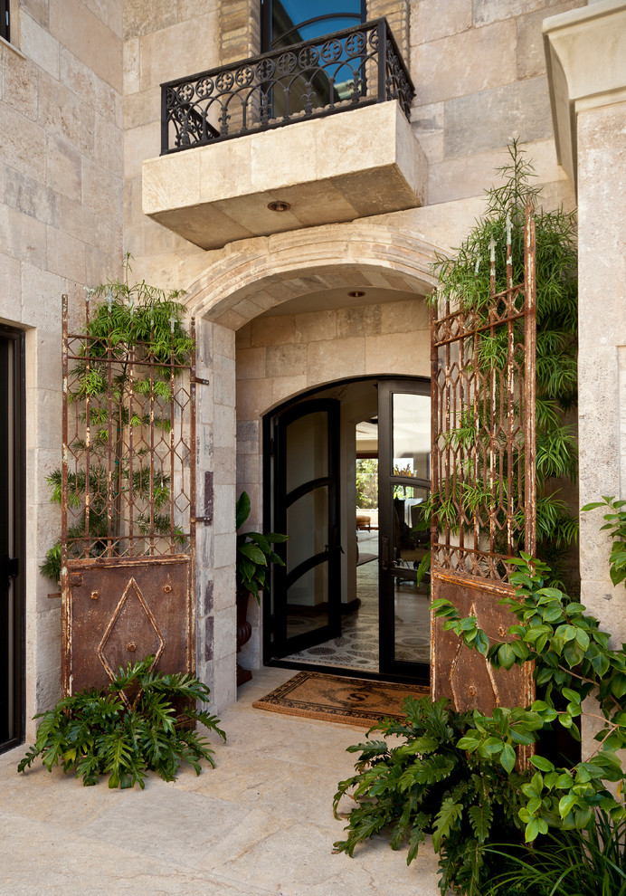 На фото: вестибюль в средиземноморском стиле с бежевыми стенами и двустворчатой входной дверью с
