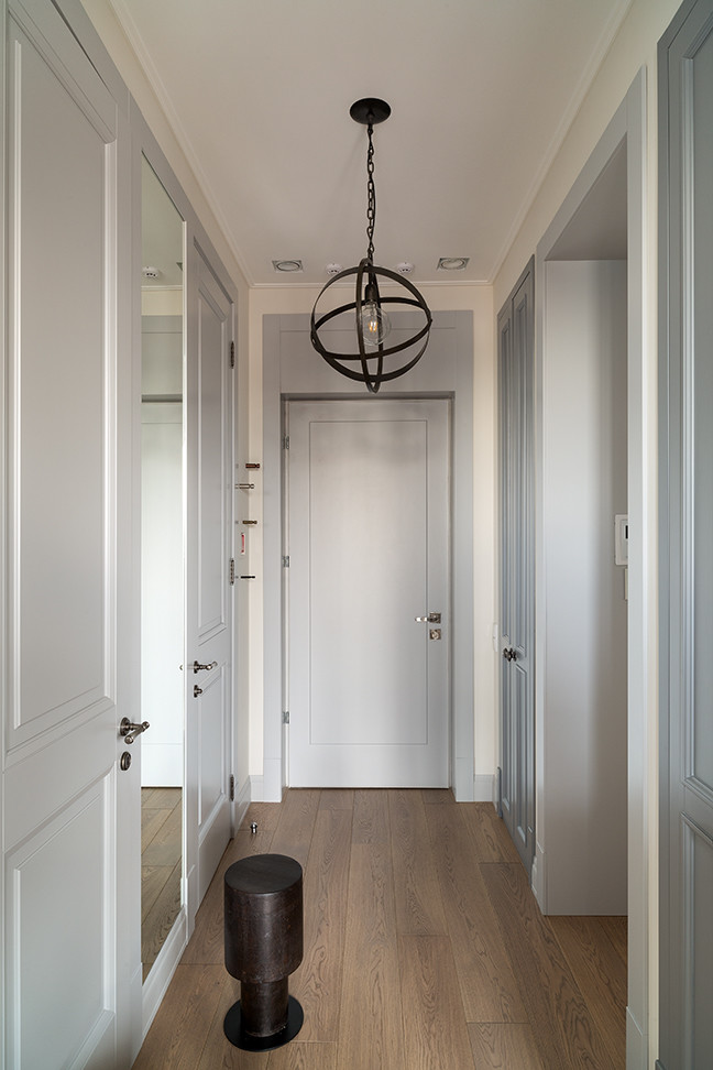 Ejemplo de puerta principal contemporánea con paredes blancas, suelo de madera en tonos medios, puerta simple, puerta gris y suelo beige