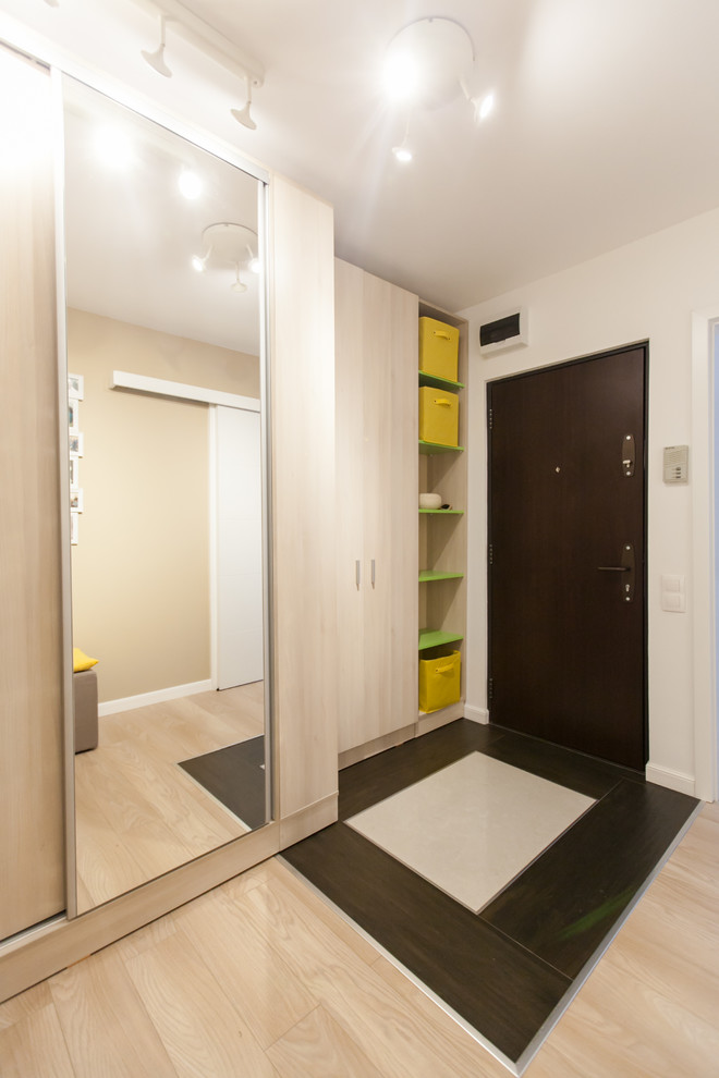 Immagine di un piccolo corridoio contemporaneo con pareti beige, una porta singola e una porta marrone