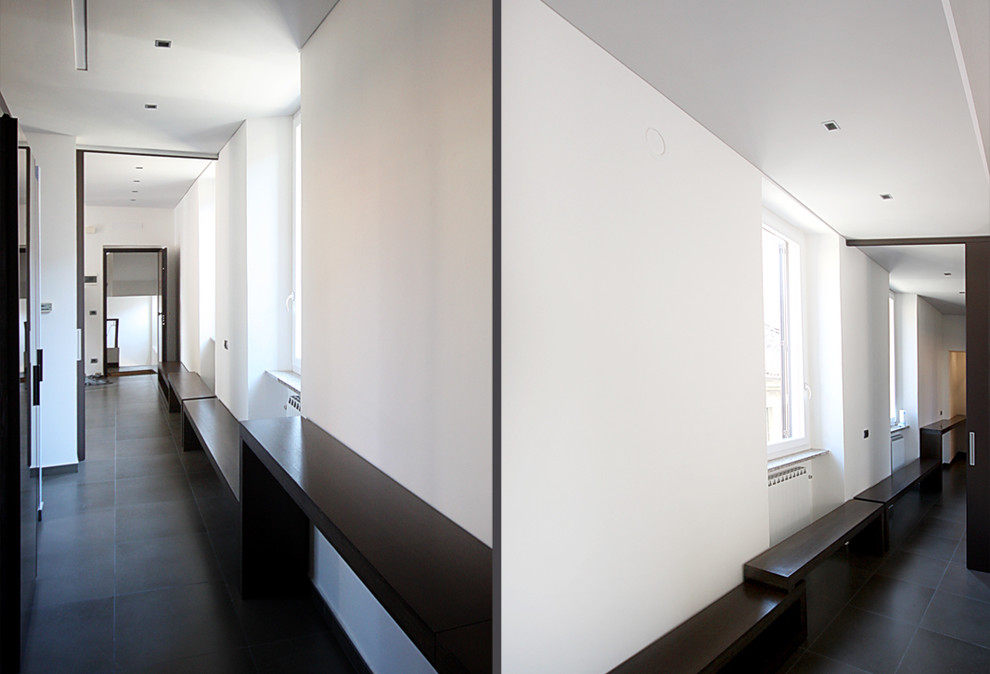 Ispirazione per un corridoio contemporaneo di medie dimensioni con pareti bianche, pavimento in gres porcellanato, una porta singola e una porta bianca