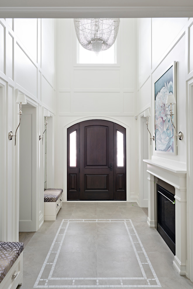 Immagine di un grande ingresso tradizionale con pareti bianche, pavimento con piastrelle in ceramica, una porta singola, una porta in legno scuro e pavimento beige