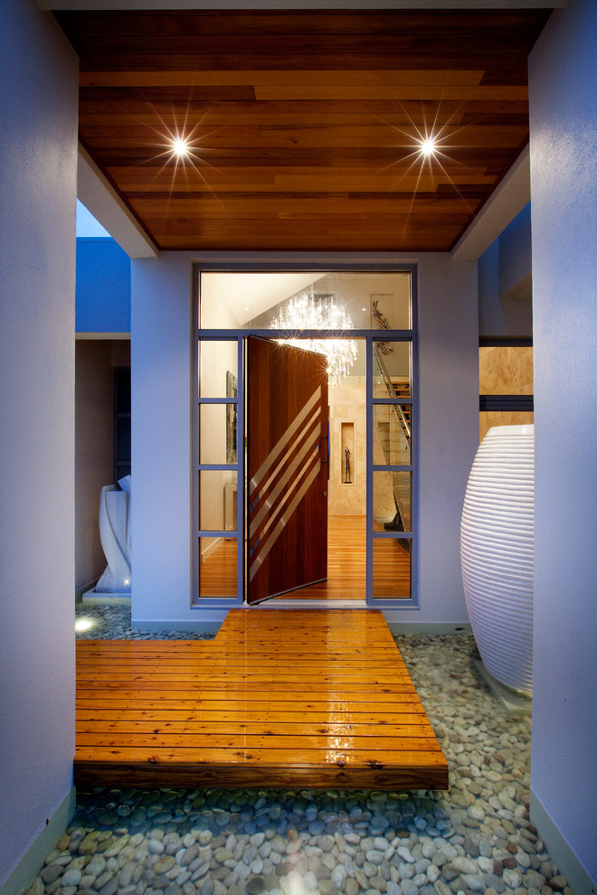 Esempio di una porta d'ingresso minimal con una porta a pivot e una porta in legno scuro