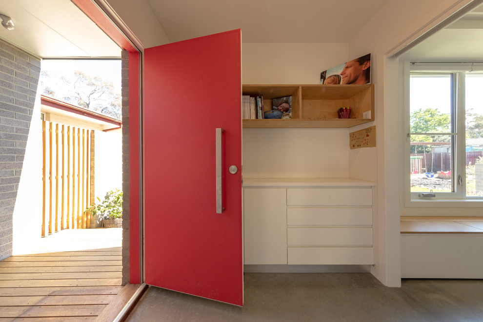 Modelo de distribuidor actual pequeño con paredes blancas, suelo de cemento, puerta doble, puerta roja y suelo gris