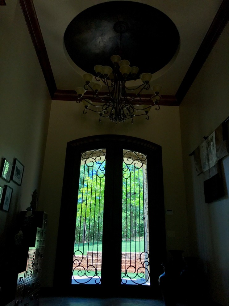 Пример оригинального дизайна: входная дверь среднего размера в стиле неоклассика (современная классика) с коричневыми стенами, двустворчатой входной дверью и черной входной дверью