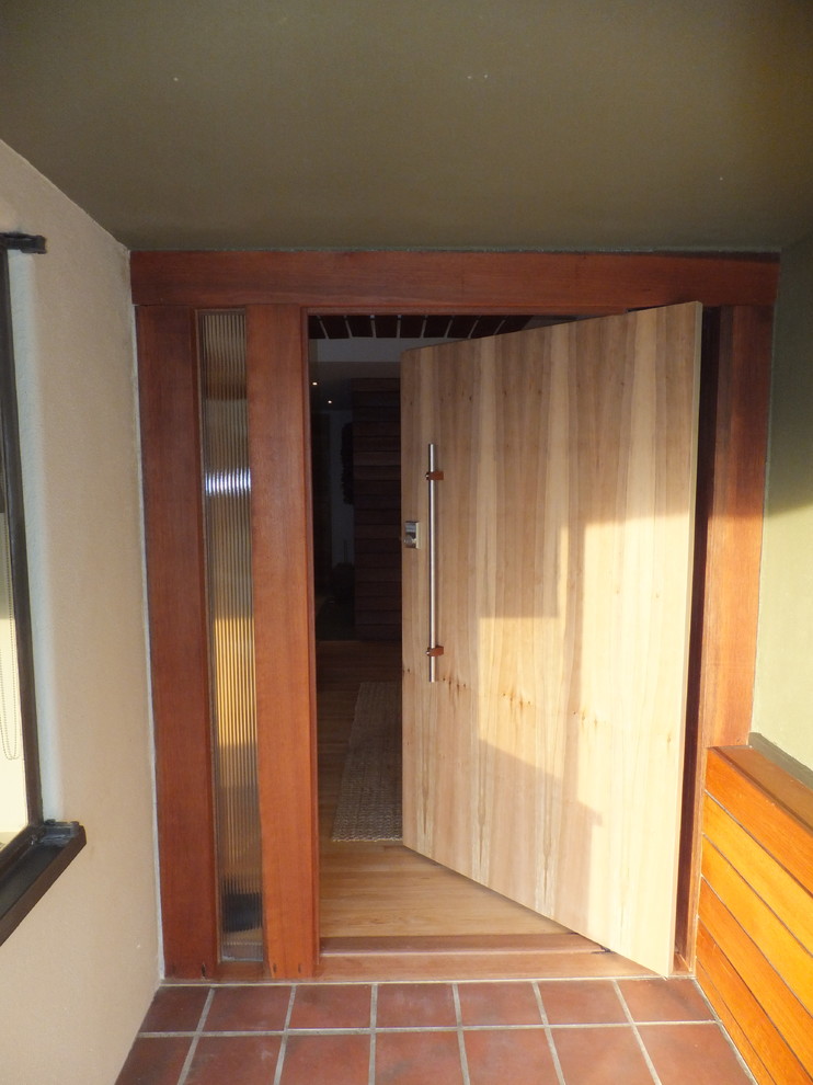 Inspiration for a modern entryway remodel in Los Angeles with a light wood front door
