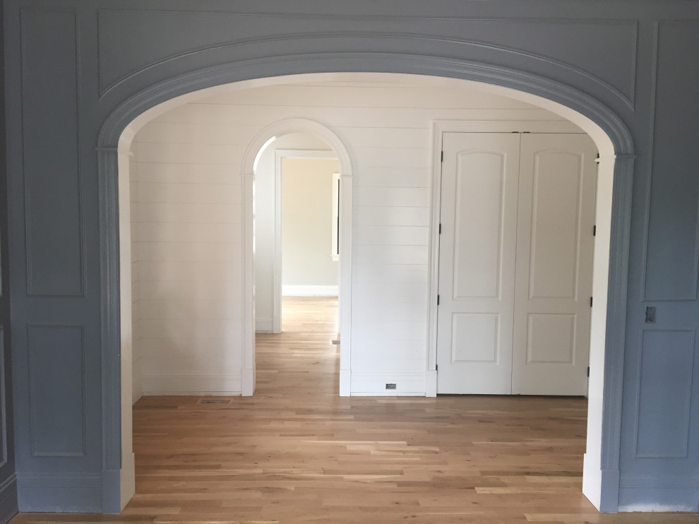 Immagine di un ingresso country di medie dimensioni con pareti blu, pavimento in legno massello medio, una porta singola, una porta in legno scuro, pavimento marrone e pareti in perlinato