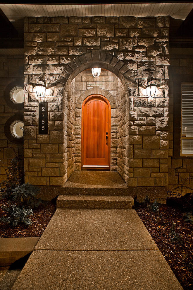 Cette image montre une porte d'entrée traditionnelle avec une porte simple et une porte en bois brun.