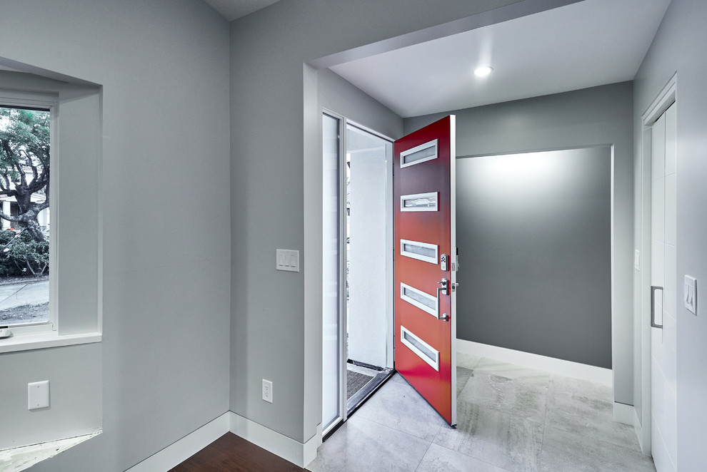 Ispirazione per una porta d'ingresso design di medie dimensioni con una porta singola, una porta rossa, pareti grigie, pavimento in gres porcellanato e pavimento grigio