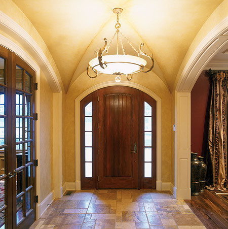 Immagine di un ingresso classico di medie dimensioni con pareti beige, pavimento in pietra calcarea, una porta singola e una porta in legno scuro