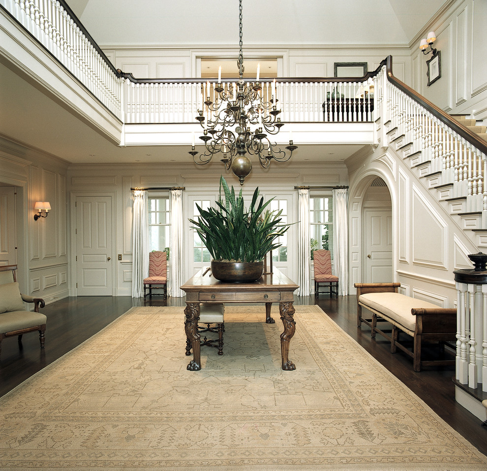Huge elegant foyer photo in New York with white walls and a white front door