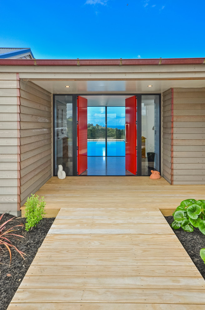 Foto di una porta d'ingresso minimalista di medie dimensioni con pareti marroni, pavimento in legno massello medio, una porta a due ante, una porta rossa e pavimento marrone