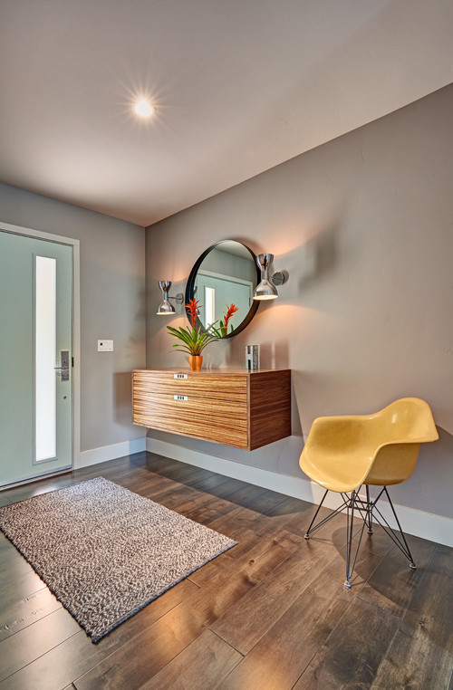 The Elegance of Floating and Wall-Mounted Vanities with modern wood design, round mirror, and stylish lighting in a contemporary bathroom