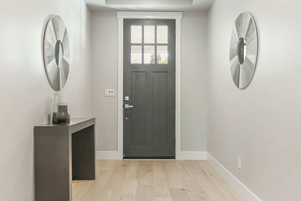 Modelo de distribuidor campestre de tamaño medio con paredes grises, suelo de madera clara, puerta simple, puerta gris y suelo blanco