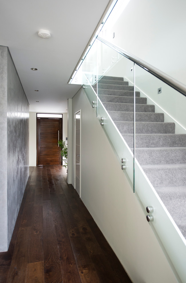 Esempio di un corridoio design con pareti bianche, parquet scuro, una porta singola, una porta in legno bruno e pavimento marrone