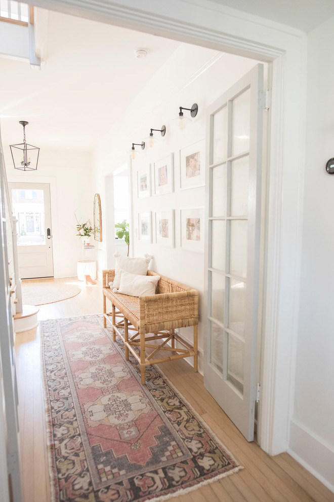 Foto di una porta d'ingresso minimal di medie dimensioni con pareti bianche, parquet chiaro e pavimento beige