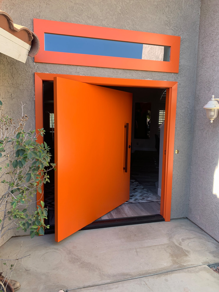 Große Moderne Haustür mit grauer Wandfarbe, Betonboden, Drehtür, oranger Haustür und weißem Boden in Sonstige