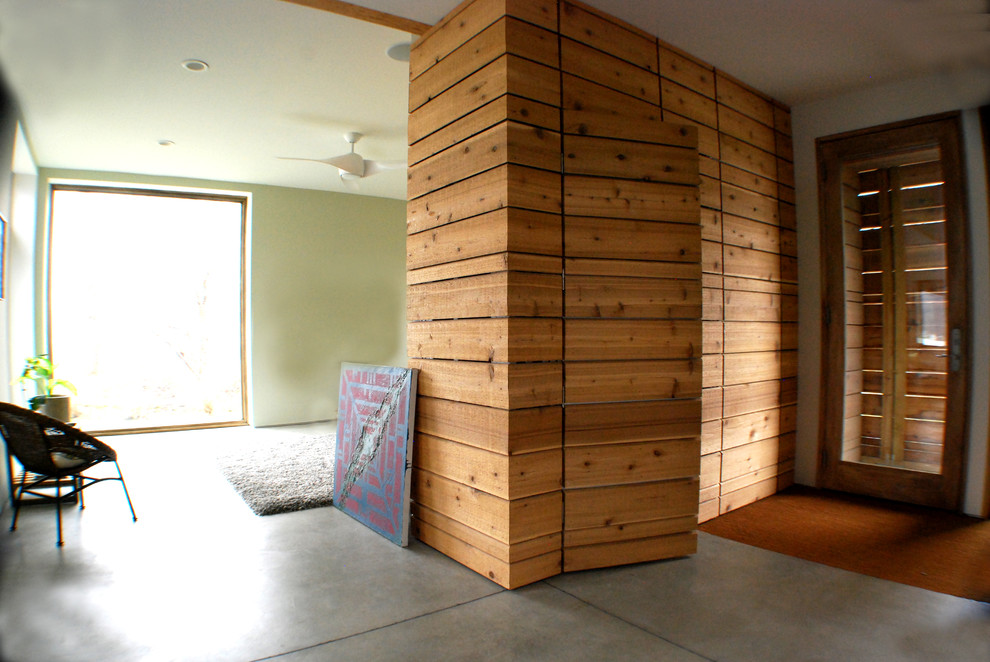 Inspiration pour une porte d'entrée minimaliste avec sol en béton ciré, une porte simple et une porte en bois brun.