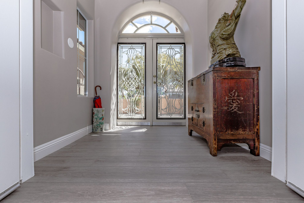 Example of a large asian vinyl floor and gray floor entryway design in Las Vegas with a white front door and gray walls