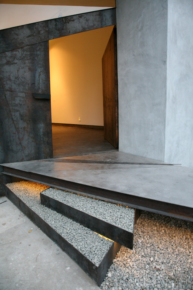Entryway - mid-sized contemporary concrete floor entryway idea in Los Angeles with gray walls and a metal front door