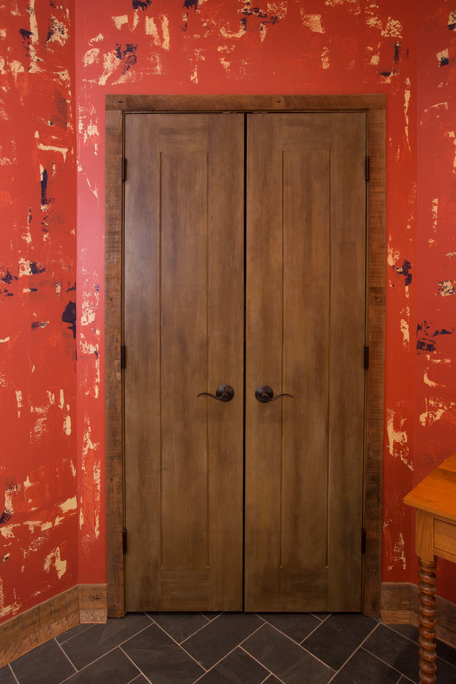 Ispirazione per una porta d'ingresso rustica di medie dimensioni con pavimento in ardesia, pareti rosse, una porta a due ante, una porta in legno scuro e pavimento grigio