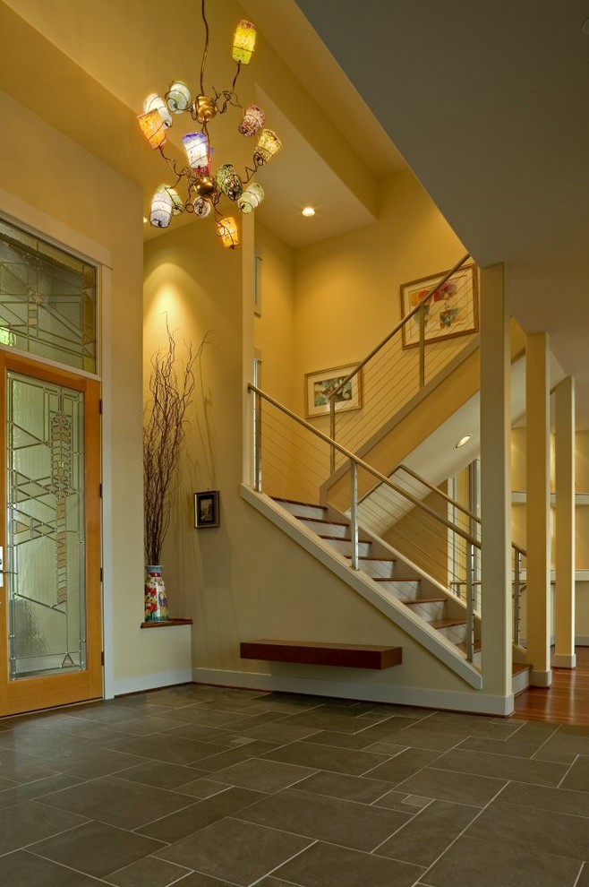シアトルにあるラグジュアリーな広いコンテンポラリースタイルのおしゃれな玄関ドア (黄色い壁、ガラスドア、磁器タイルの床) の写真
