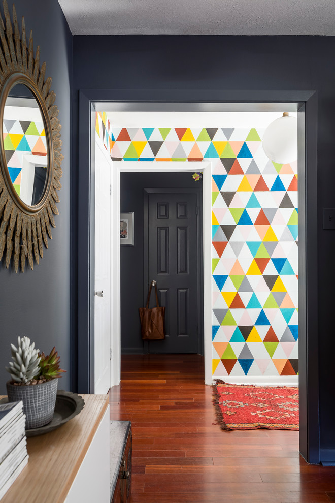 Cette photo montre un petit hall d'entrée éclectique avec un mur multicolore, parquet foncé, une porte simple, une porte en verre et un sol marron.