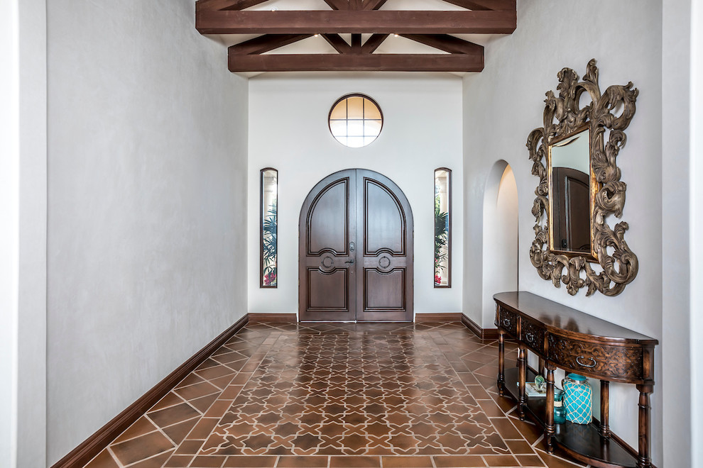 Entryway - mid-sized mediterranean terra-cotta tile and red floor entryway idea in San Francisco with white walls and a dark wood front door