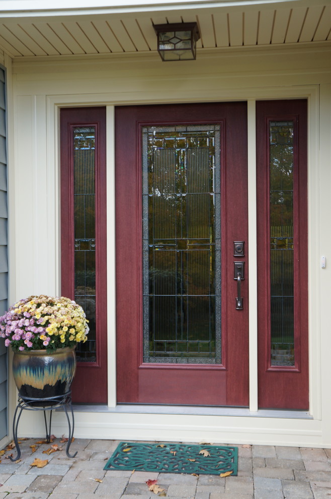 На фото: входная дверь среднего размера в стиле кантри с стеклянной входной дверью, одностворчатой входной дверью, бежевыми стенами и кирпичным полом с