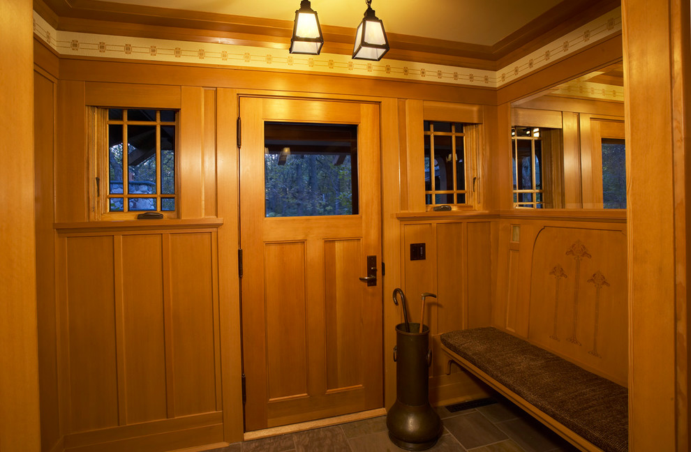 Uriger Eingang mit Vestibül, gelber Wandfarbe, Schieferboden, Einzeltür und hellbrauner Holzhaustür in Minneapolis
