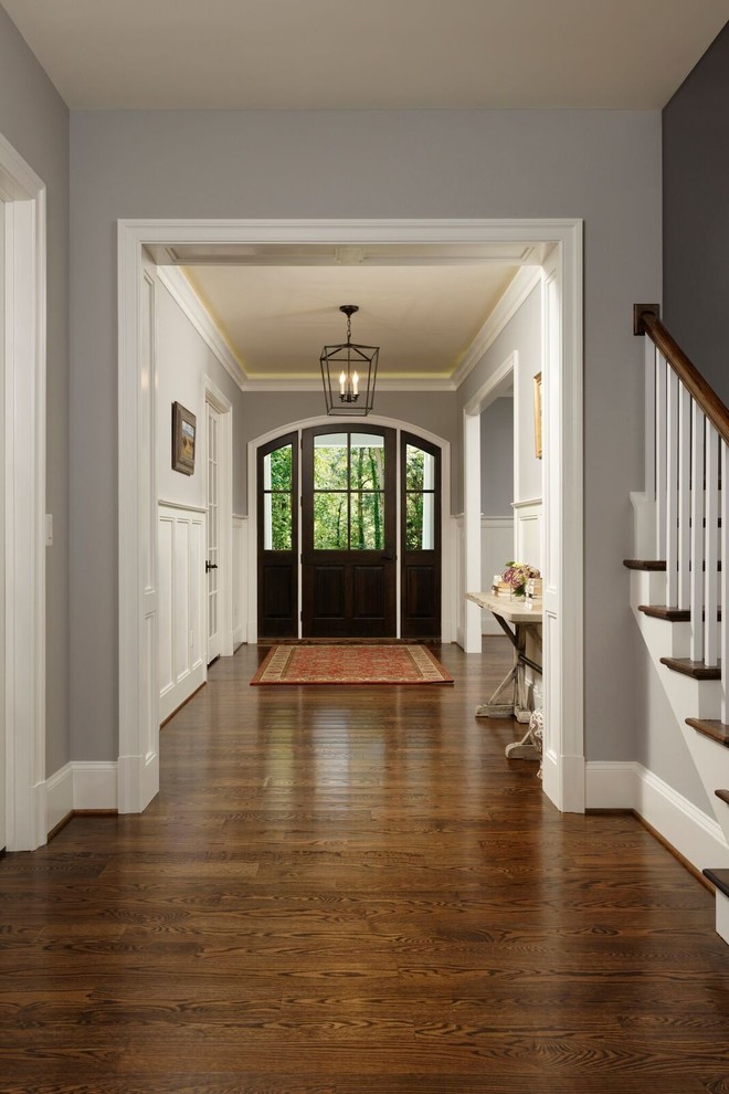 Esempio di una porta d'ingresso classica di medie dimensioni con pavimento in legno massello medio, pavimento marrone, pareti marroni, una porta singola e una porta in legno scuro