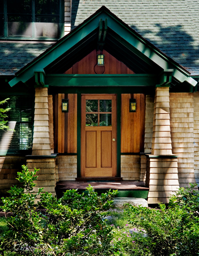 Réalisation d'une entrée craftsman avec une porte simple et une porte en bois brun.