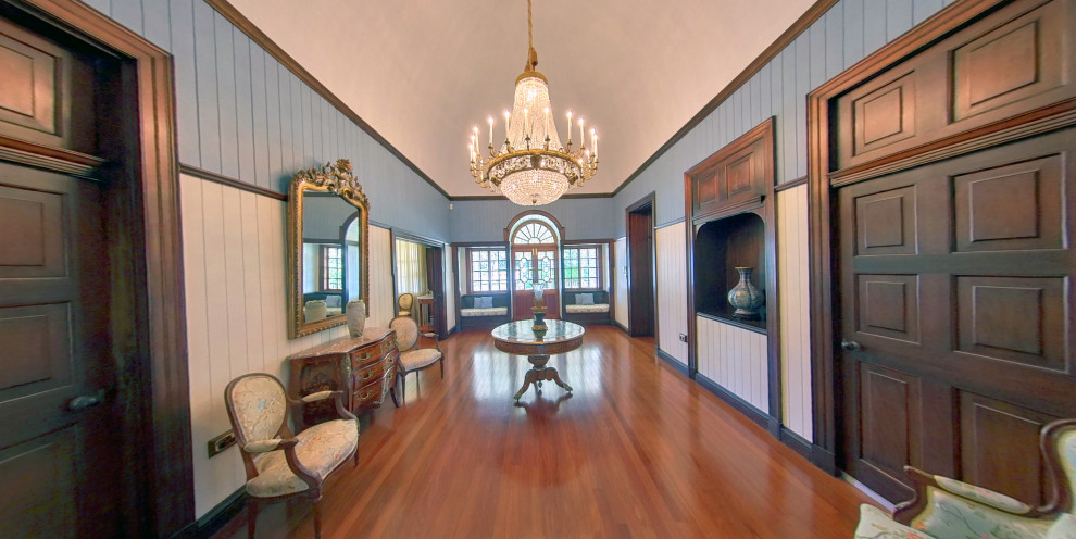 Example of a large classic medium tone wood floor, vaulted ceiling and wood wall entryway design in Brisbane with white walls and a medium wood front door
