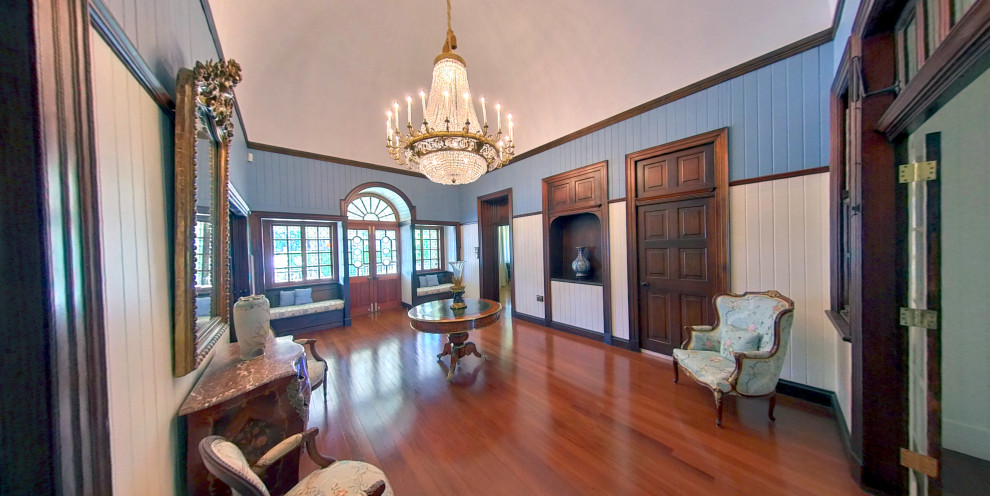 Inspiration for a large timeless medium tone wood floor, vaulted ceiling and wood wall entryway remodel in Brisbane with white walls and a medium wood front door